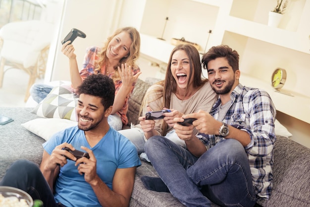 Photo friends having fun on the couch with video games