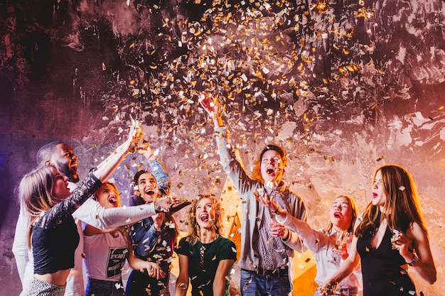 Friends having fun in falling confetti