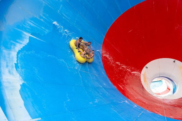 Friends having fun on huge water slide in aqua park