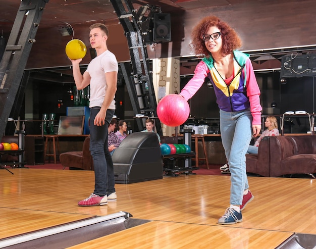 Photo friends having fun and playing bowling