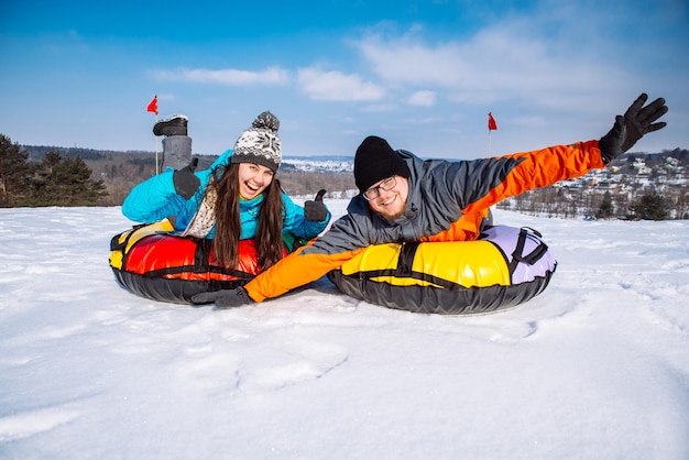 Friends having fun snow tubing winter activity