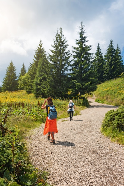 Friends having fun together, women hiking in the mountains. Happy travelers, goal, success, freedom and achievement concept. Carpathian mountains, Hoverla, Ukraine.