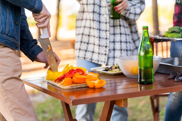 写真 ビールと一緒に屋外で昼食をとっている友達