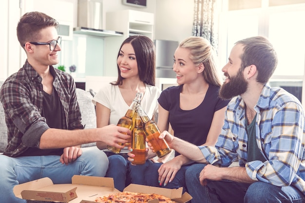 Friends having party together indoors eating pizza