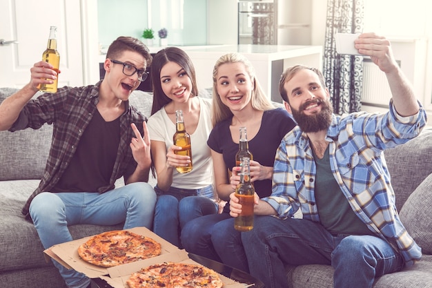 Friends having party together indoors eating pizza