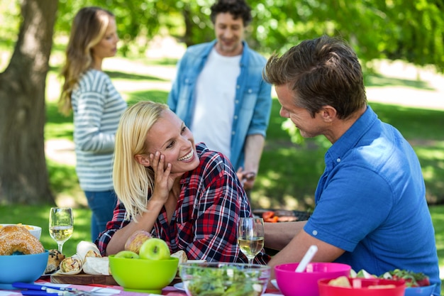 Amici che hanno un picnic con vino e barbecue