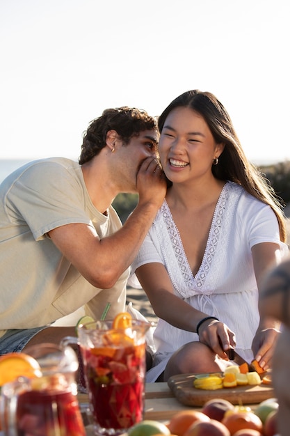 Amici che fanno una festa di sangria sulla spiaggia