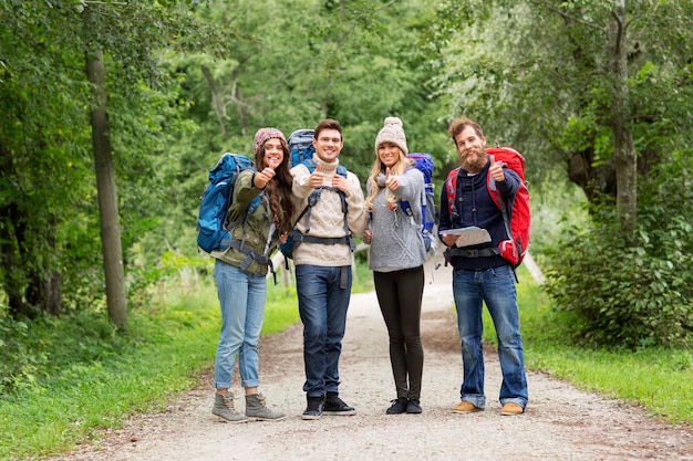 friends hiking with backpacks and show thumbs up