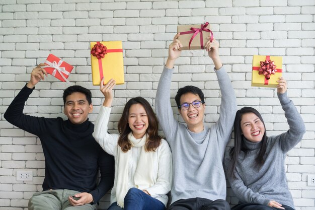 Friends holding gift boxes at home for christmas and happy new year 