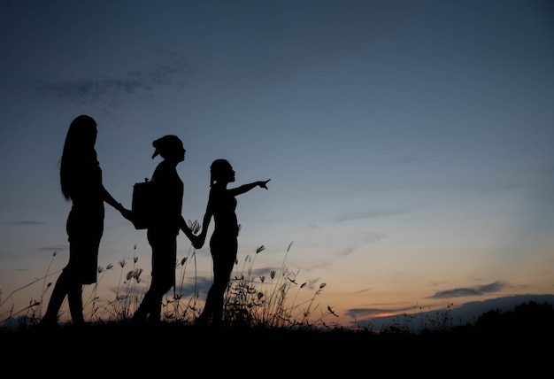 Friends holding hands at sunset.