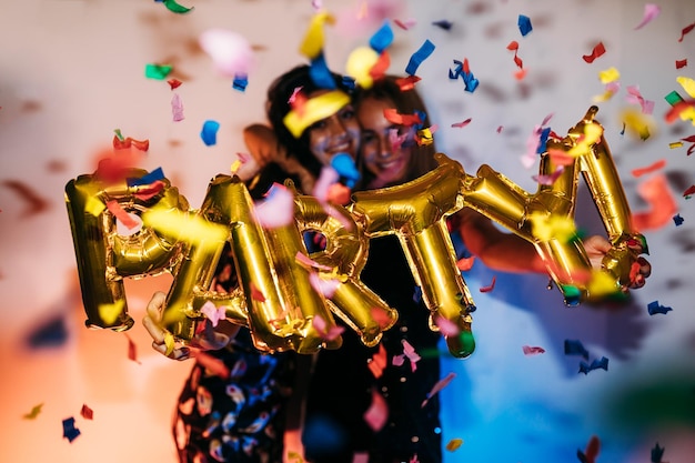 Friends holding helium balloons at party