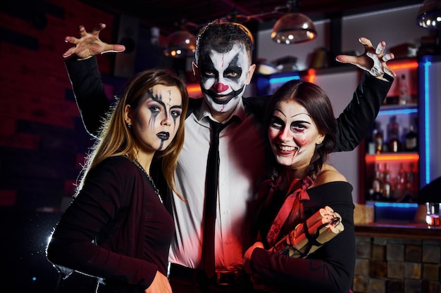 Friends is on the thematic halloween party in scary makeup and costumes have fun and posing for the camera together.