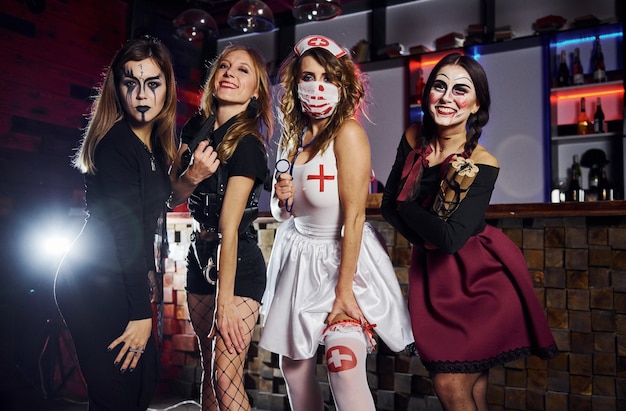 Foto gli amici sono alla festa tematica di halloween con trucco e costumi spaventosi.