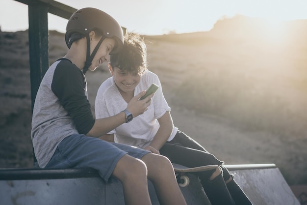 Amici che guardano lo smartphone e sorridono seduti all'aperto