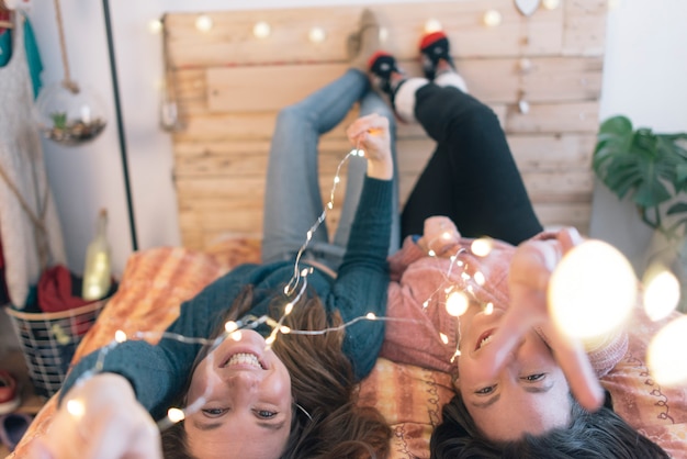 Photo friends lying on bed and smiling. friendship concept