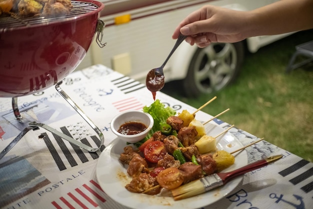 バーベキューをする仲間たち 自然の中で大火でBBQグリル 食事会