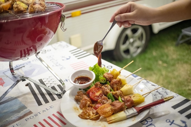 자연 속에서 뜨거운 불에 굽는 바비큐 BBQ를 만드는 친구들저녁 파티