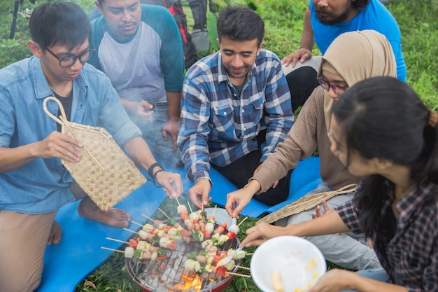 Friends making a barbecue together outdoors