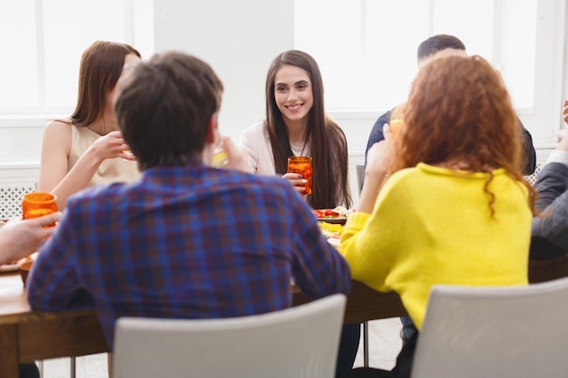 Friends meeting, dinner together at home party. Young people having fun, eating meals and drinking wine