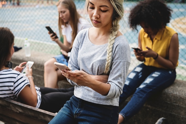 Photo friends in the park using smartphones