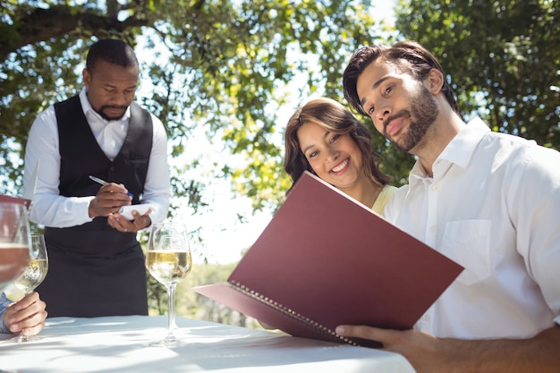 Photo friends placing order to waiter