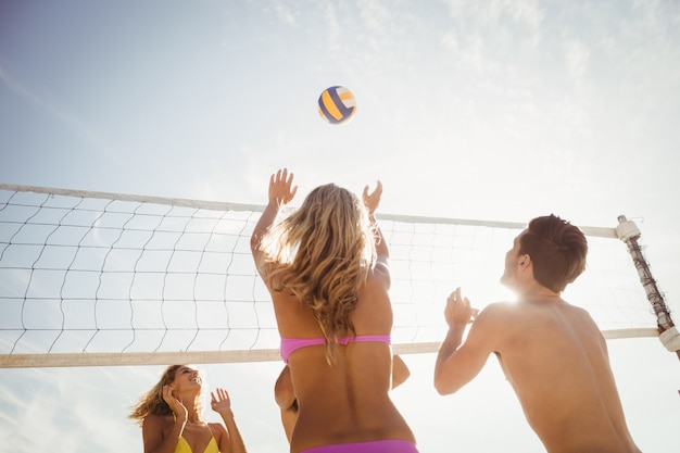 Photo friends playing beach volleyball