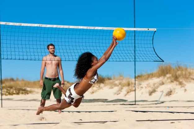 Friends playing beach volleyball