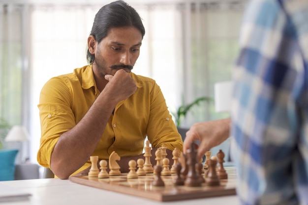 Friends playing chess at home