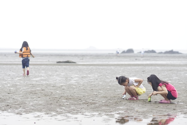 写真 友達がビーチで砂で遊んでいる