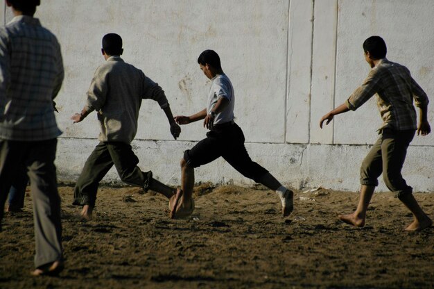 Photo friends playing soccer on grassy field