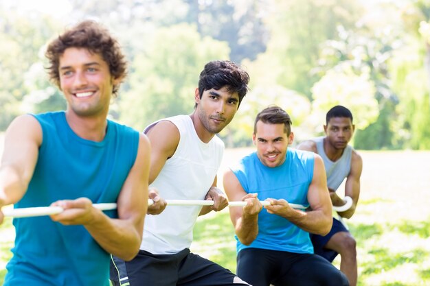 Friends playing tug of war in park