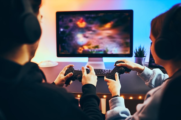 Friends playing video game gamers playing championship tournament competition and fun gaming room