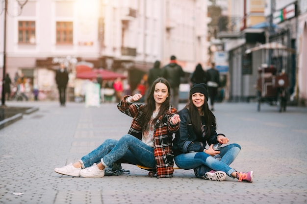 friends posing sitting on the street