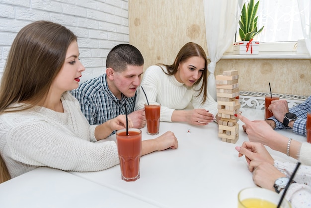 Friends in pub eating pizza and playing tower game