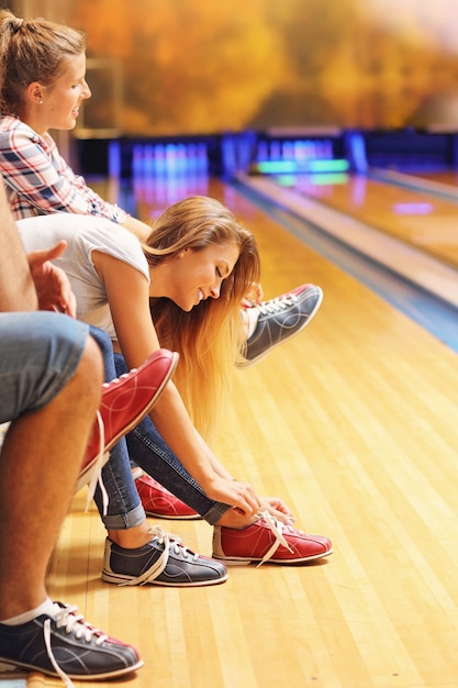 friends putting on bowling shoes