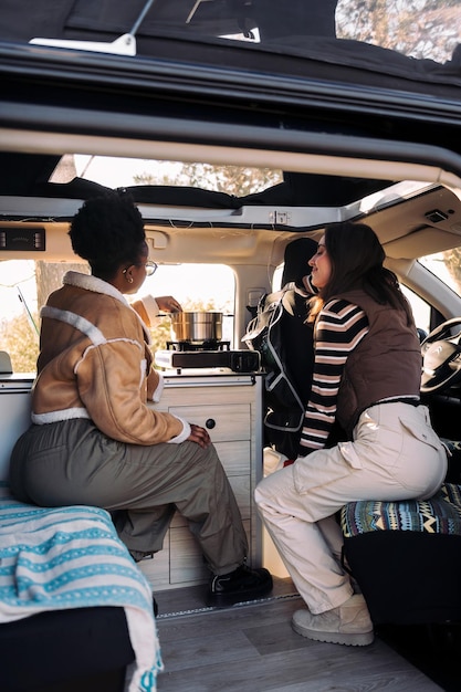 Friends in a road trip cooking in camper van