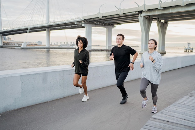 Friends run around in sportswear and sneakers The concept of people's sports in the city