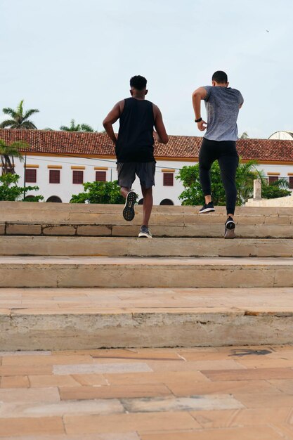 Friends running stairs together during workout in park