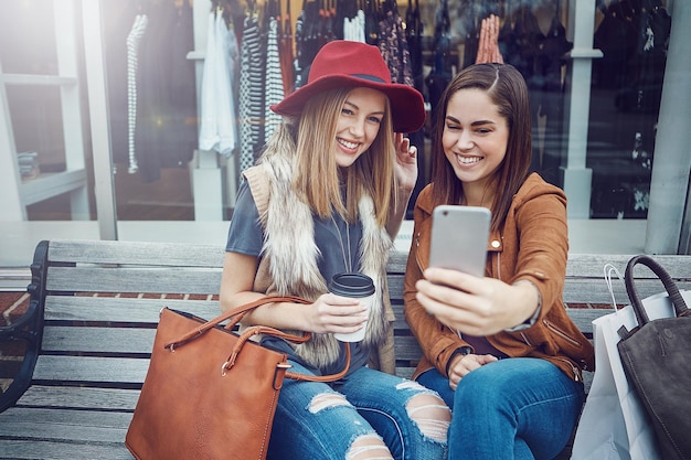 Friends selfie and shopping break with women smile and happiness together with retail sale and discount at mall Bench photograph and memory for social media customer and urban boutique store