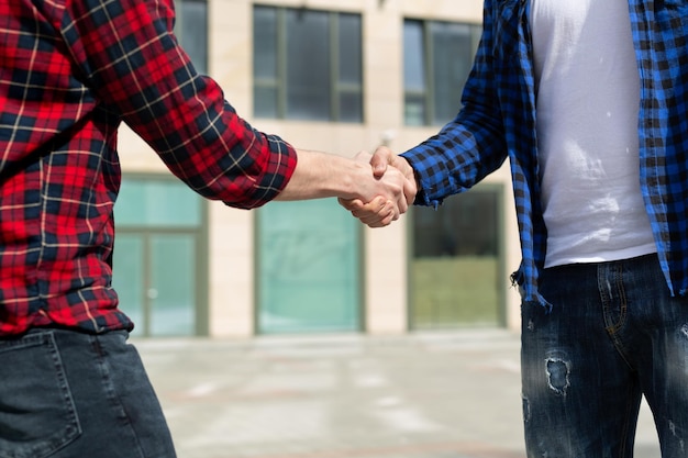 Friends shake hands on the street