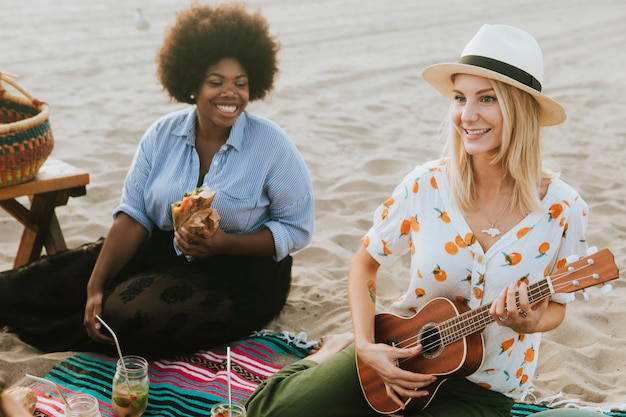 Friends singing together at a beach picnic