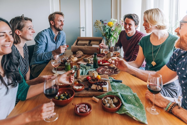 Friends sitting around the table eating home delivered tapas food