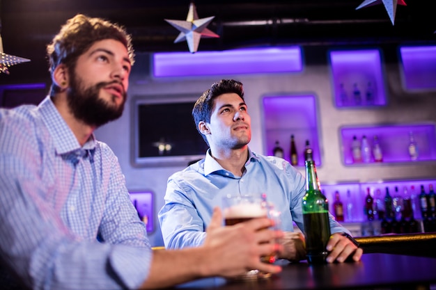 Friends sitting at bar counter and having beer