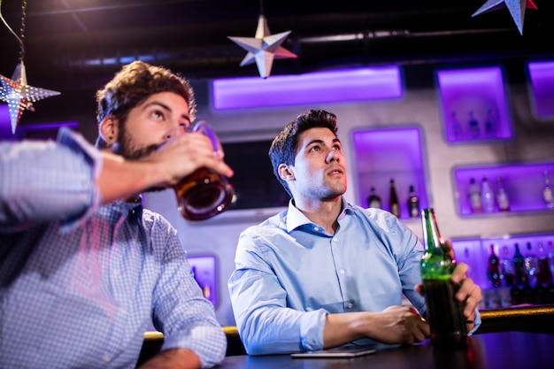 Friends sitting at bar counter and having beer