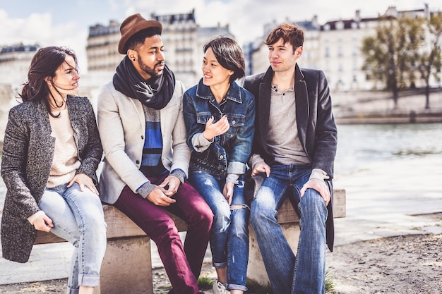 Friends sitting on bench in city