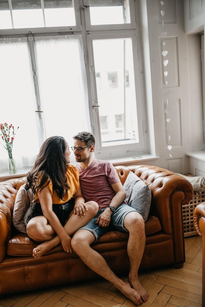 Photo friends sitting on sofa at home