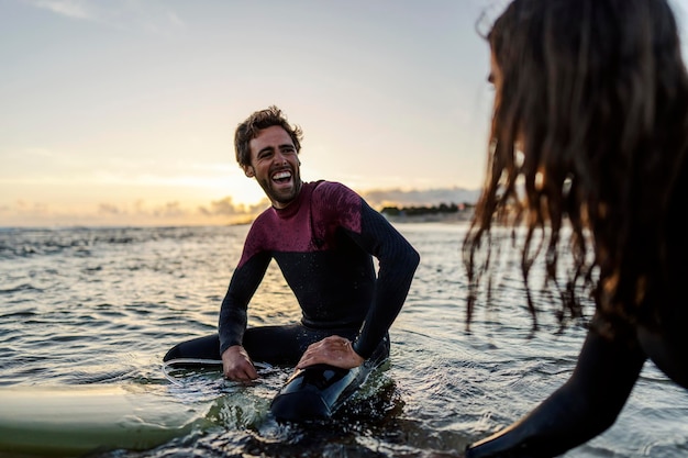 Friends sitting on surfboards and enjoying the ocean