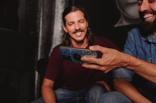 Photo friends smiling while they watch social media platform