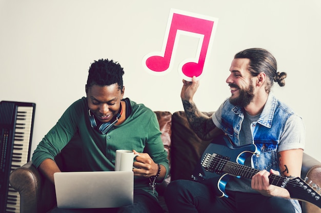 Friends in a songwriting process holding a musical note