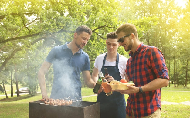 Photo friends spending time in nature and having barbecue